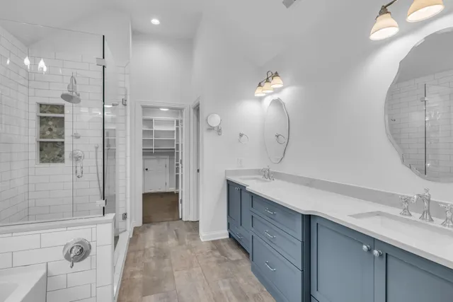 a spacious bathroom with a double vanity sink mirror and shower