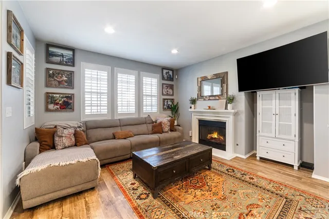 a living room with furniture a flat screen tv and a fireplace