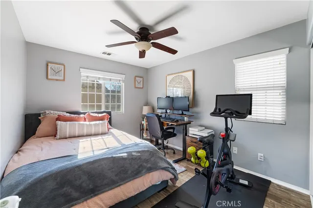 a bedroom with a bed a computer on the desk and a couch