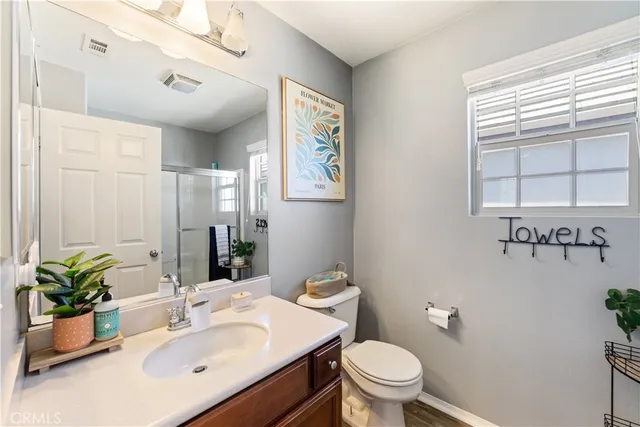 a bathroom with a sink vanity granite and toilet