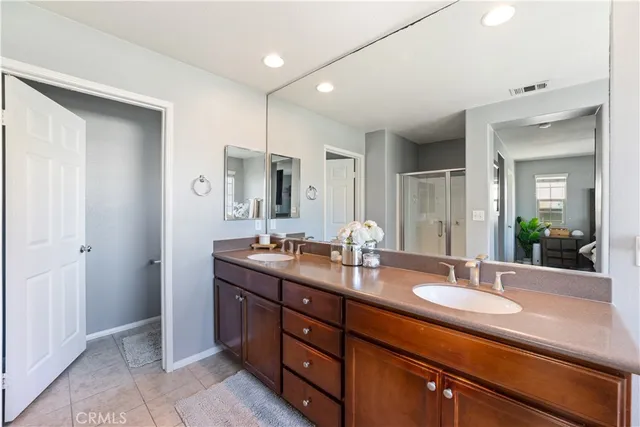 a bathroom with double vanity sinks and a mirror