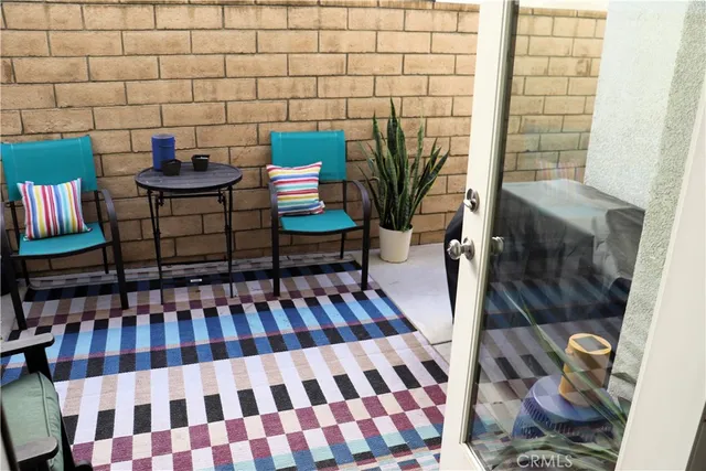 a view of a balcony with chairs and a potted plant