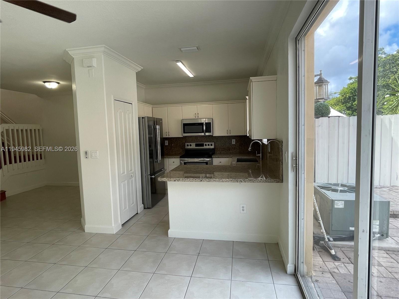 7020 Northwest 177th Street, Unit B103 Hialeah, FL 33015 - Photo 11 of 53 a kitchen with stainless steel appliances granite countertop a refrigerator and a stove