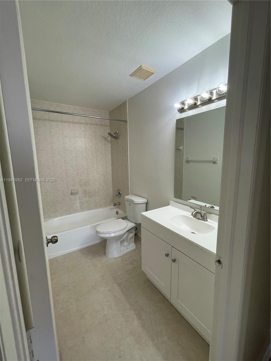7020 Northwest 177th Street, Unit B103 Hialeah, FL 33015 - Photo 22 of 53 a bathroom with a double vanity sink toilet and shower