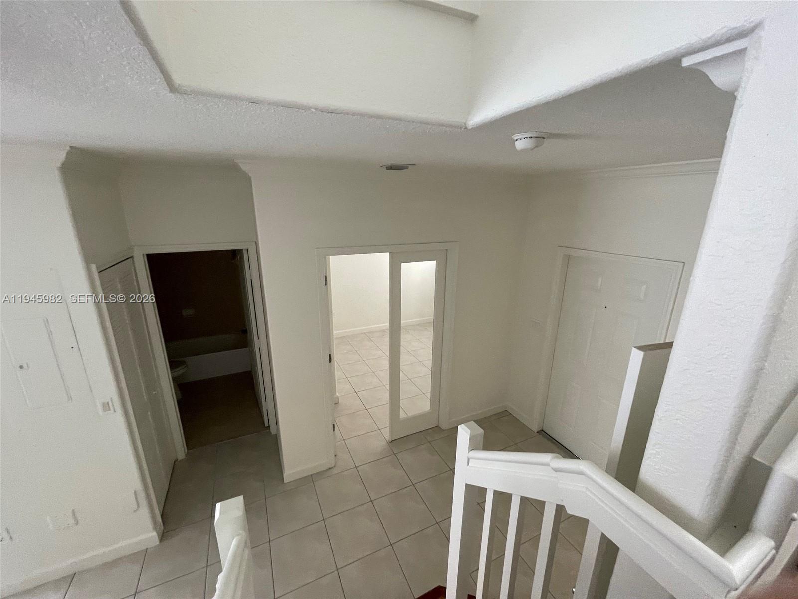 7020 Northwest 177th Street, Unit B103 Hialeah, FL 33015 - Photo 26 of 53 a view of an empty room with wooden floor and a window