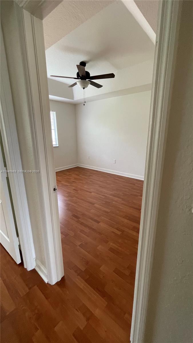 7020 Northwest 177th Street, Unit B103 Hialeah, FL 33015 - Photo 47 of 53 an empty room with wooden floor and fan