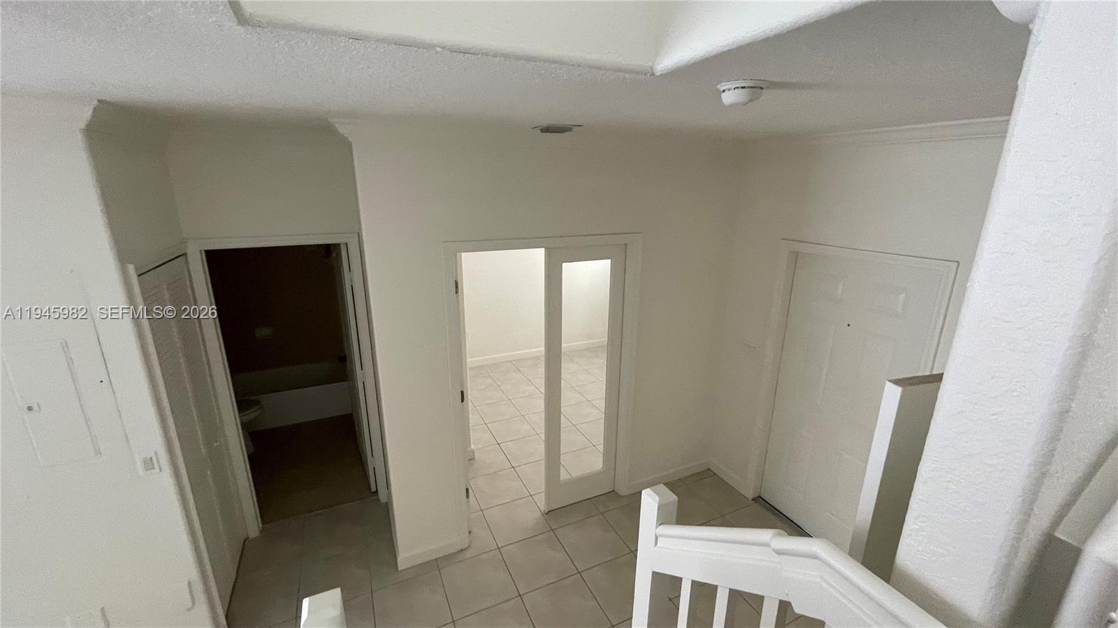7020 Northwest 177th Street, Unit B103 Hialeah, FL 33015 - Photo 53 of 53 a view of an empty room with wooden floor and a window