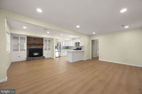 a view of a big room with wooden floor and fireplace