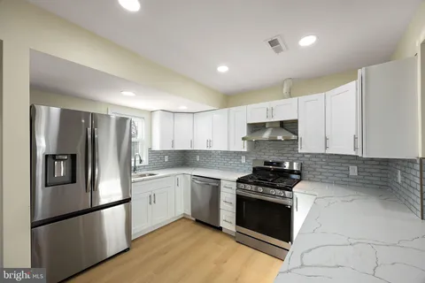 a kitchen with granite countertop stainless steel appliances and refrigerator