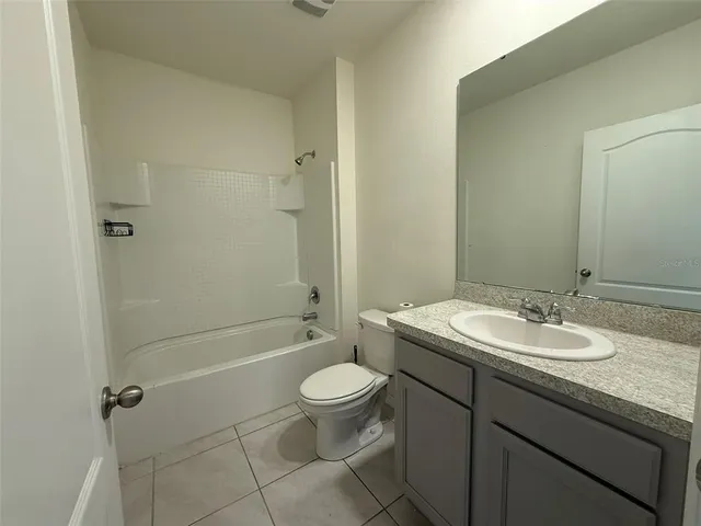 a bathroom with a granite countertop sink a toilet and shower