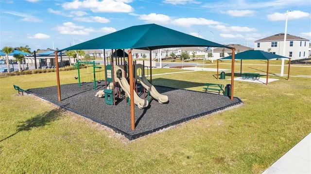 an aerial view of a house with a yard and large trees