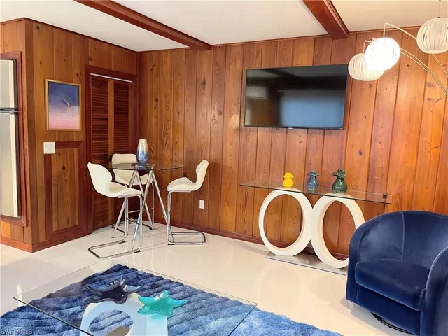 a living room with furniture a rug and white walls