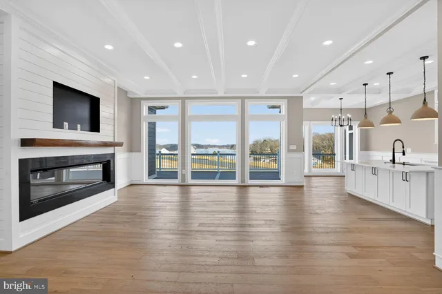 a kitchen with stainless steel appliances granite countertop a sink a stove and a wooden floors