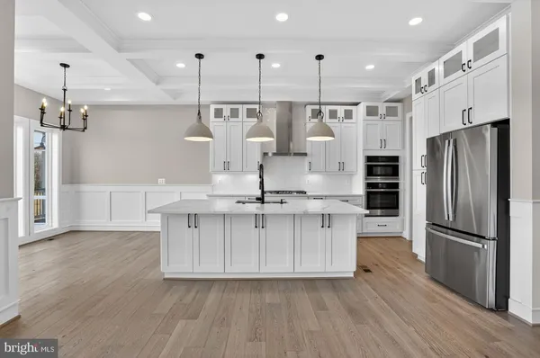 a kitchen with stainless steel appliances a sink a stove and a wooden floors