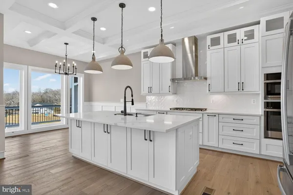 a kitchen with stainless steel appliances granite countertop a sink and a refrigerator