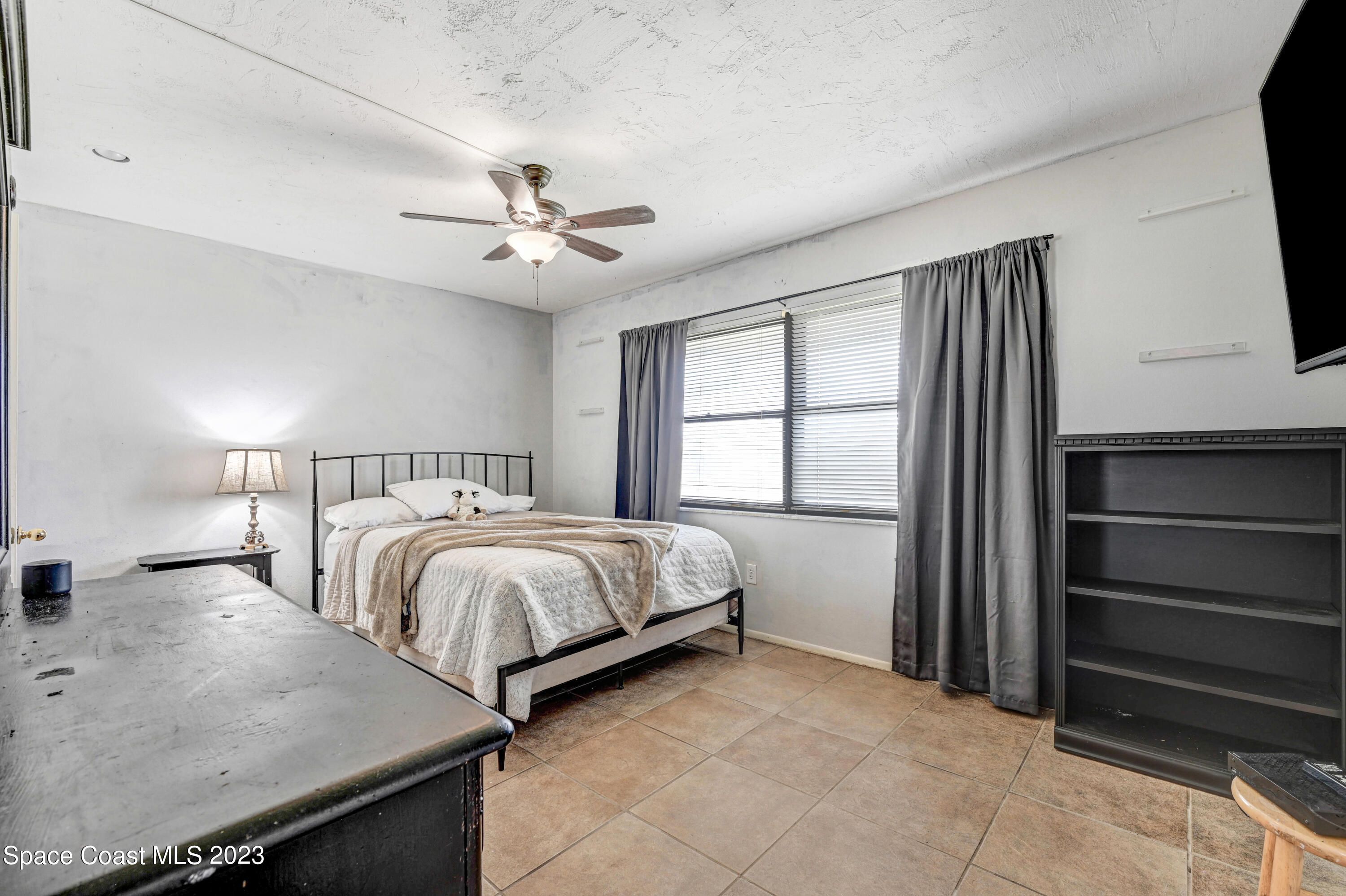 832 Damask Street Northeast Palm Bay, FL 32905 - Photo 13 of 18 a spacious bedroom with a bed and a flat screen tv