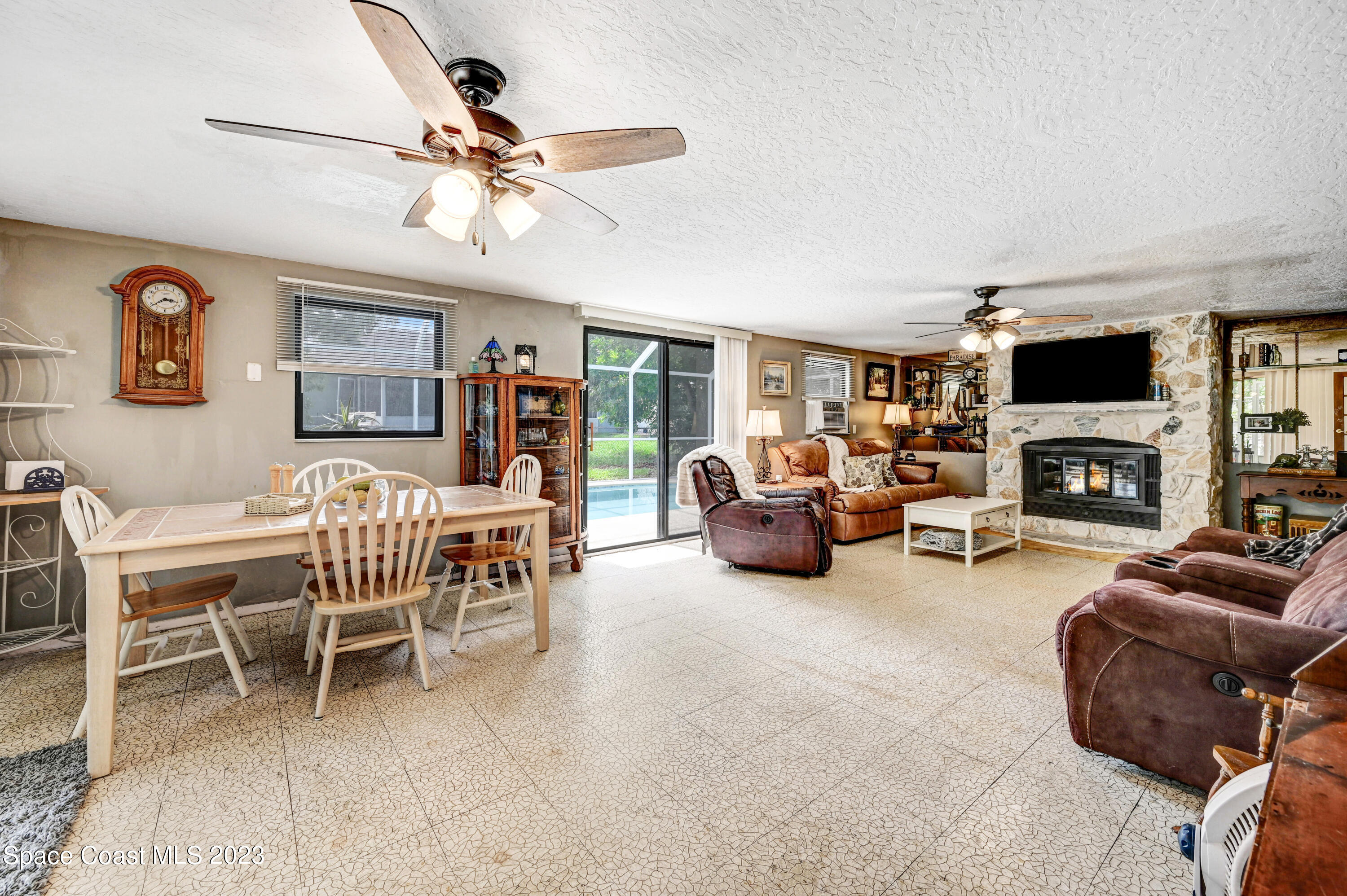 832 Damask Street Northeast Palm Bay, FL 32905 - Photo 16 of 18 a living room with furniture a fireplace and a flat screen tv