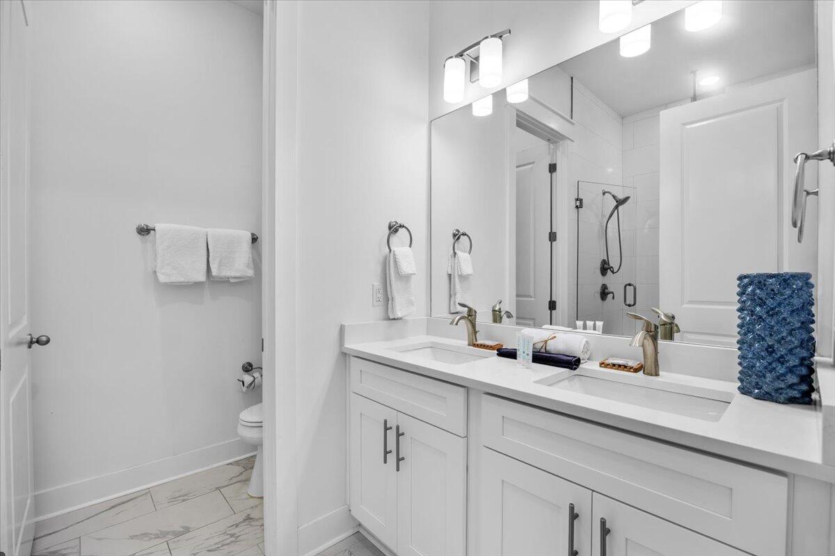 12 Caba Cove Santa Rosa Beach, FL 32459 - Photo 19 of 37 a bathroom with double vanity sink a toilet a mirror and shower