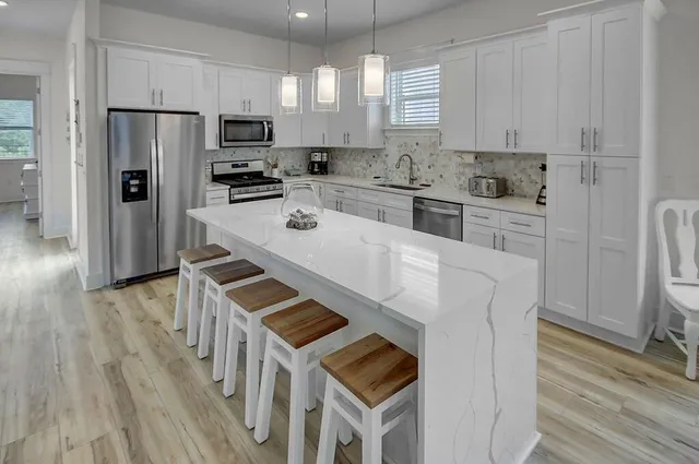 a kitchen with white cabinets and stainless steel appliances