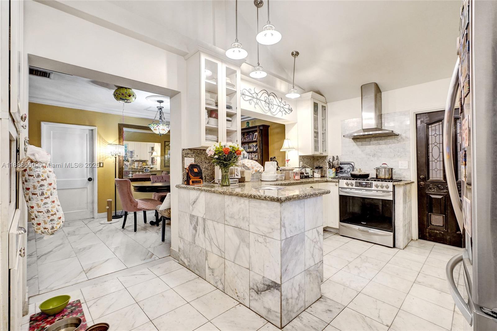 9156 Northwest 3rd Avenue Miami, FL 33150 - Photo 12 of 26 a kitchen with stainless steel appliances a stove a sink a oven a dining table and chairs