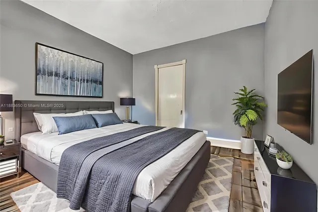 a bedroom with a bed and a flat screen tv