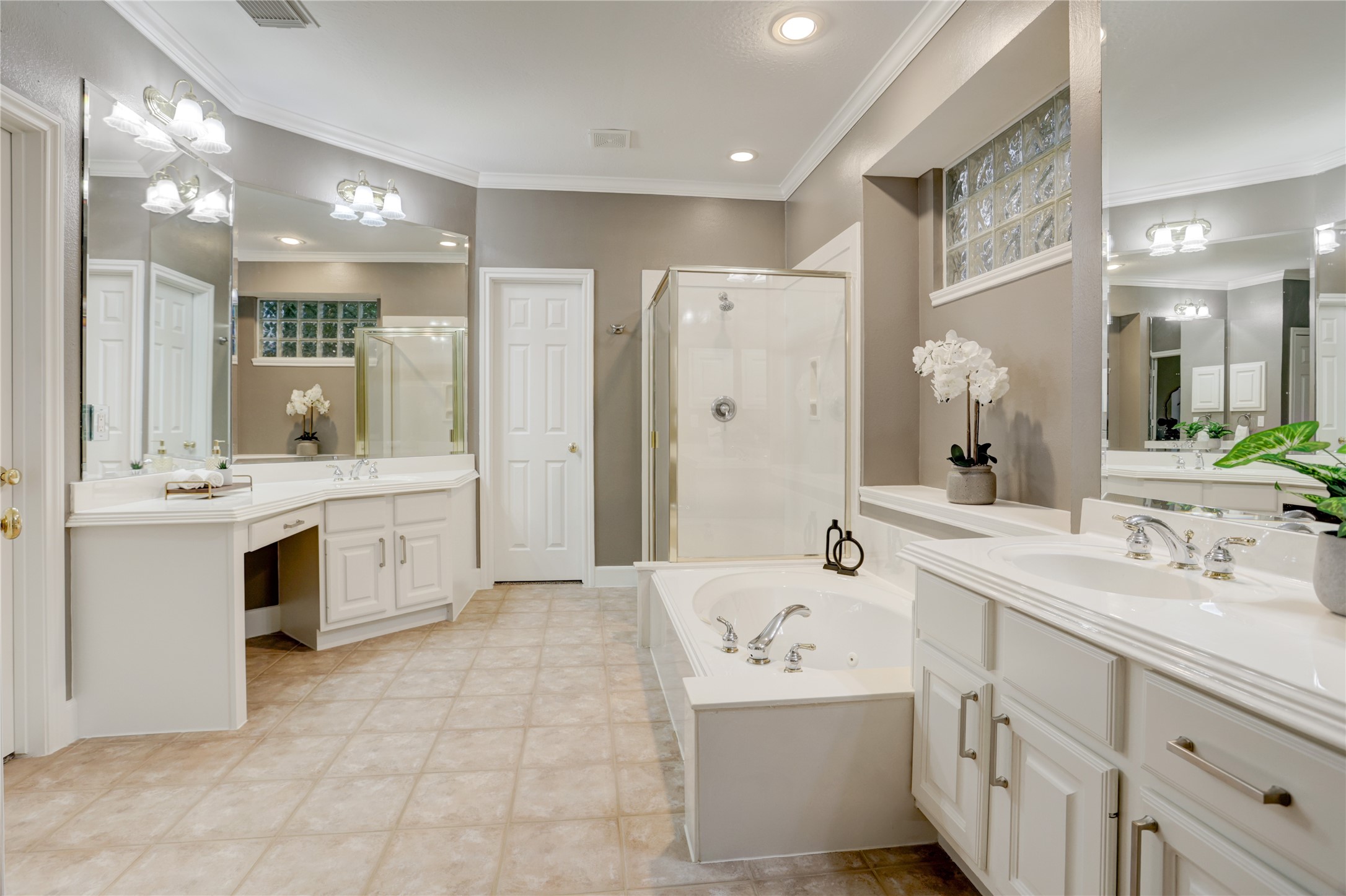 24418 Falcon Point Drive Katy, TX 77494 - Photo 15 of 40 Spacious primary bath featuring dual vanities, a dedicated makeup area, and abundant storage. Designed for comfort and functionality, the layout includes a soaking tub, separate glass-enclosed shower, and elegant finishes throughout creating a relaxing, spa-like retreat.