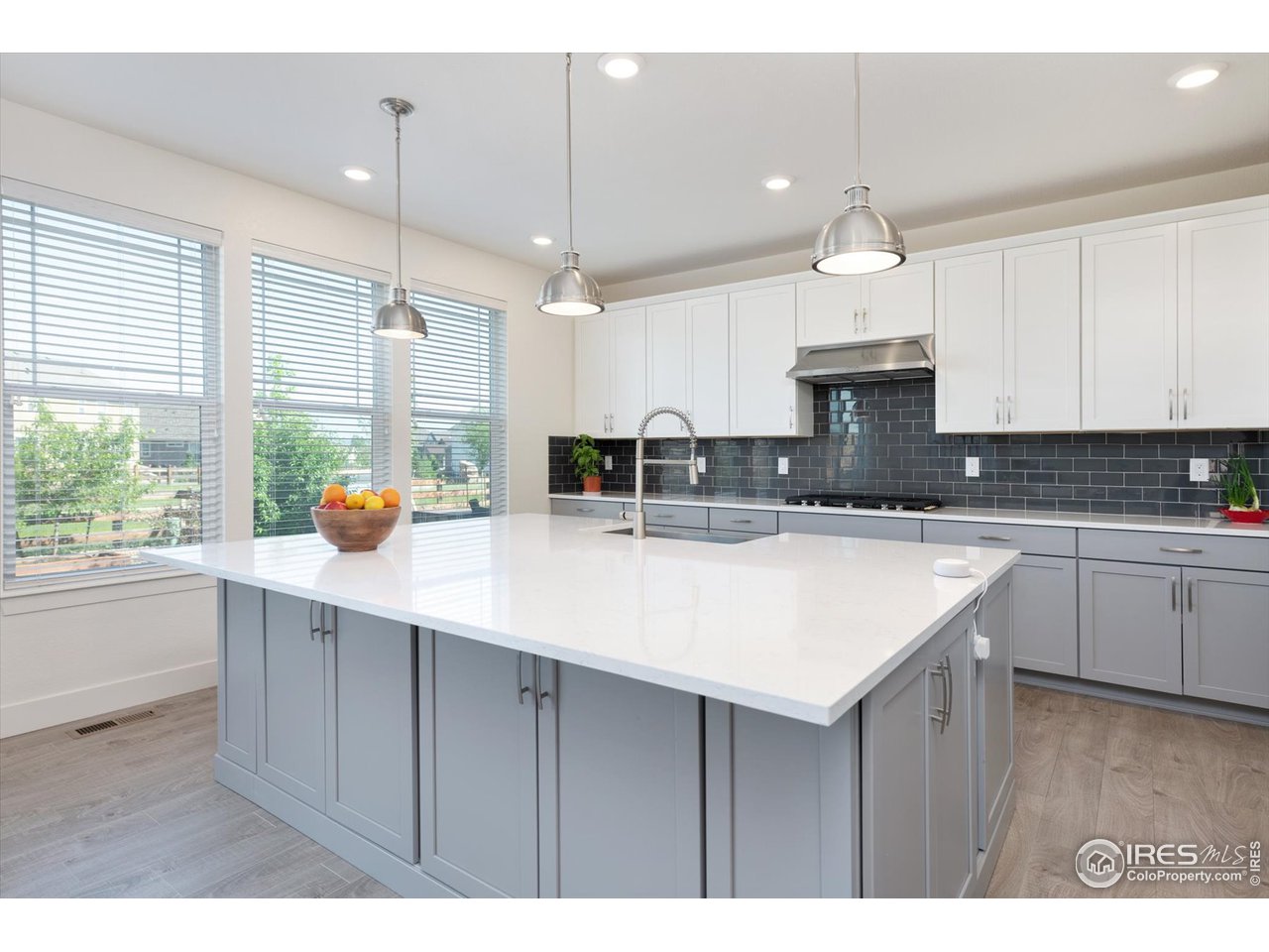 2159 Summerlin Lane Longmont, CO 80503 - Photo 12 of 37 a kitchen with kitchen island granite countertop a sink a counter space appliances and cabinets