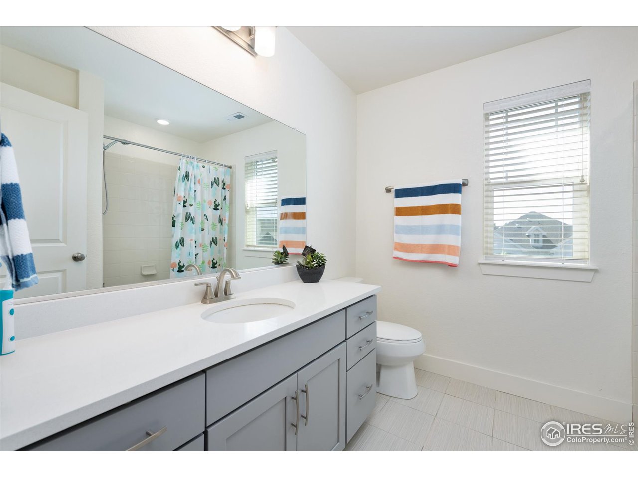 2159 Summerlin Lane Longmont, CO 80503 - Photo 30 of 37 a bathroom with a sink a toilet a mirror and a window
