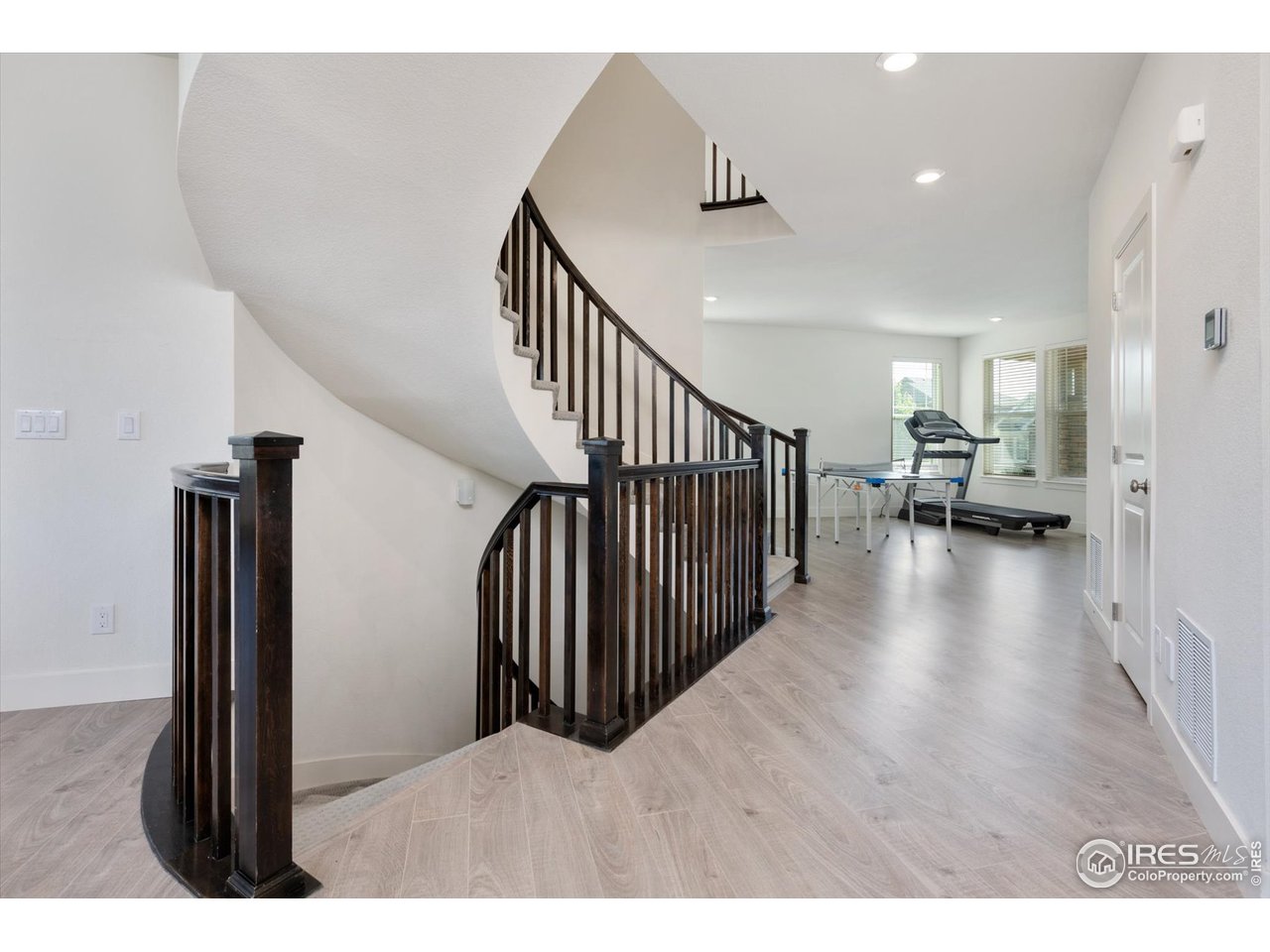 2159 Summerlin Lane Longmont, CO 80503 - Photo 6 of 37 a view of a hallway with wooden floor and stairs