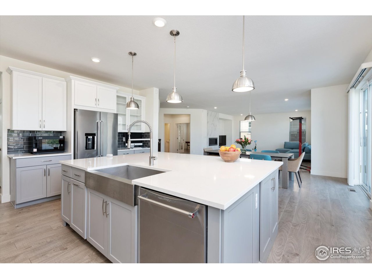 2159 Summerlin Lane Longmont, CO 80503 - Photo 9 of 37 a large kitchen with kitchen island a sink a stove a center island and a refrigerator