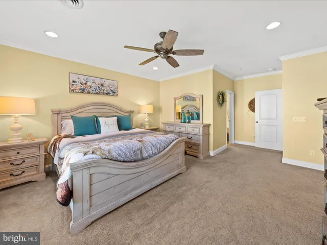 a bedroom with a large bed and ceiling fan