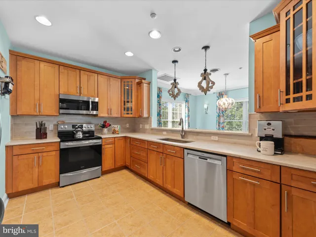 a kitchen with stainless steel appliances granite countertop a stove a sink dishwasher and a microwave oven with cabinets