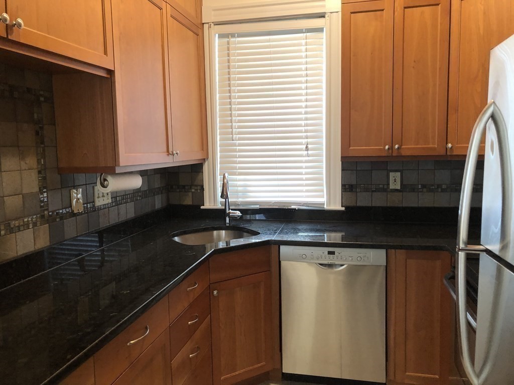 96 St Paul Street, Unit 2 Brookline, MA 02446 - Photo 6 of 14 a kitchen with granite countertop cabinets sink and window