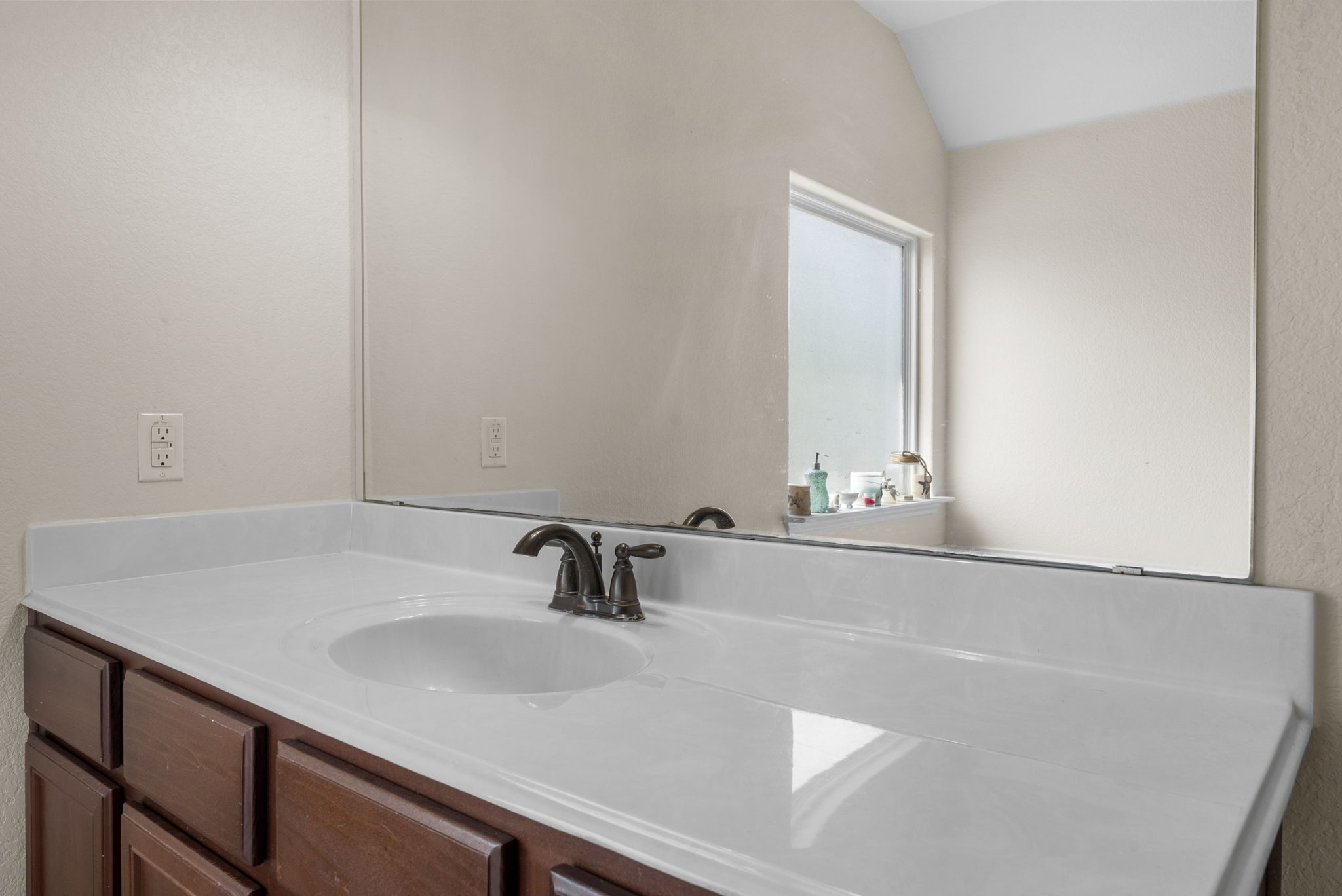 1617 Treeta Trail Kyle, TX 78640 - Photo 30 of 39 Bathroom featuring vanity, a textured wall, and vaulted ceiling