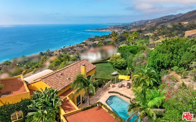 an aerial view of ocean beach and residential houses with outdoor space