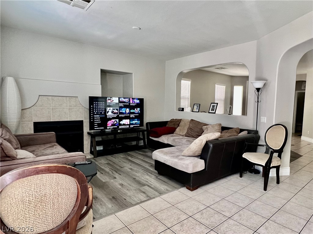 151 Short Ruff Way Las Vegas, NV 89148 - Photo 10 of 17 Arched pass-throughs and an inviting fireplace anchor this versatile main-level living space.