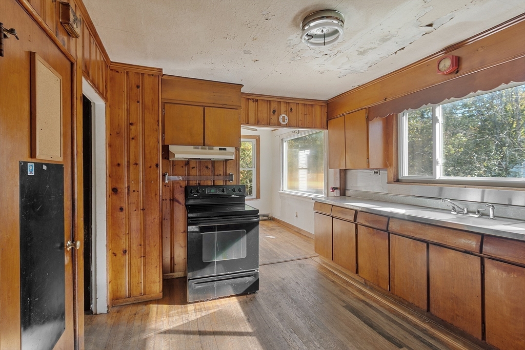 31 South Street Townsend, MA 01469 - Photo 8 of 42 a kitchen with stainless steel appliances granite countertop a refrigerator a sink dishwasher a stove and a dining table with wooden floor