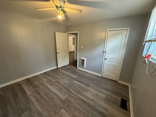 a view of empty room with wooden floor