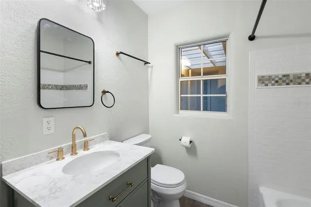 a bathroom with a toilet sink vanity and mirror