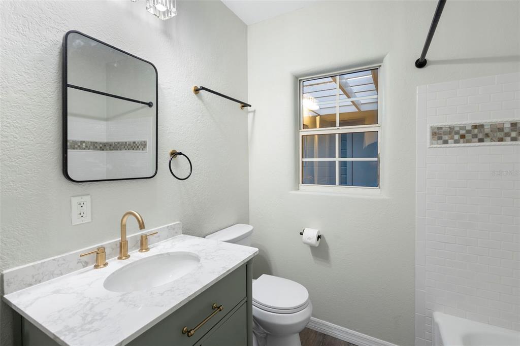 124 Evergreen Avenue Edgewater, FL 32132 - Photo 17 of 36 a bathroom with a toilet sink vanity and mirror