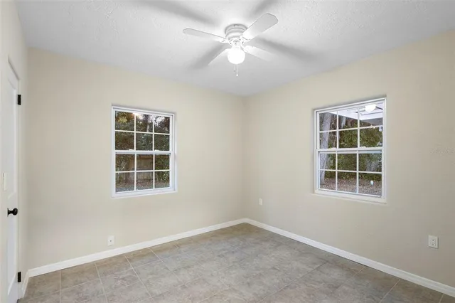 an empty room with a window and a fan