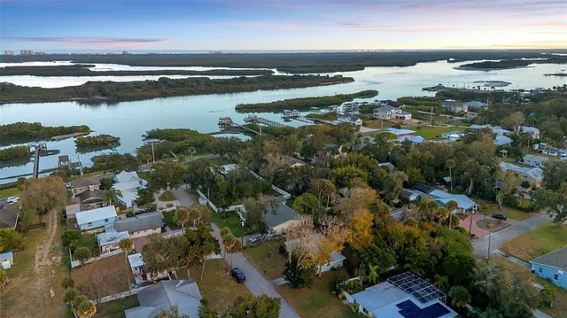 an aerial view of ocean and residential houses with outdoor space
