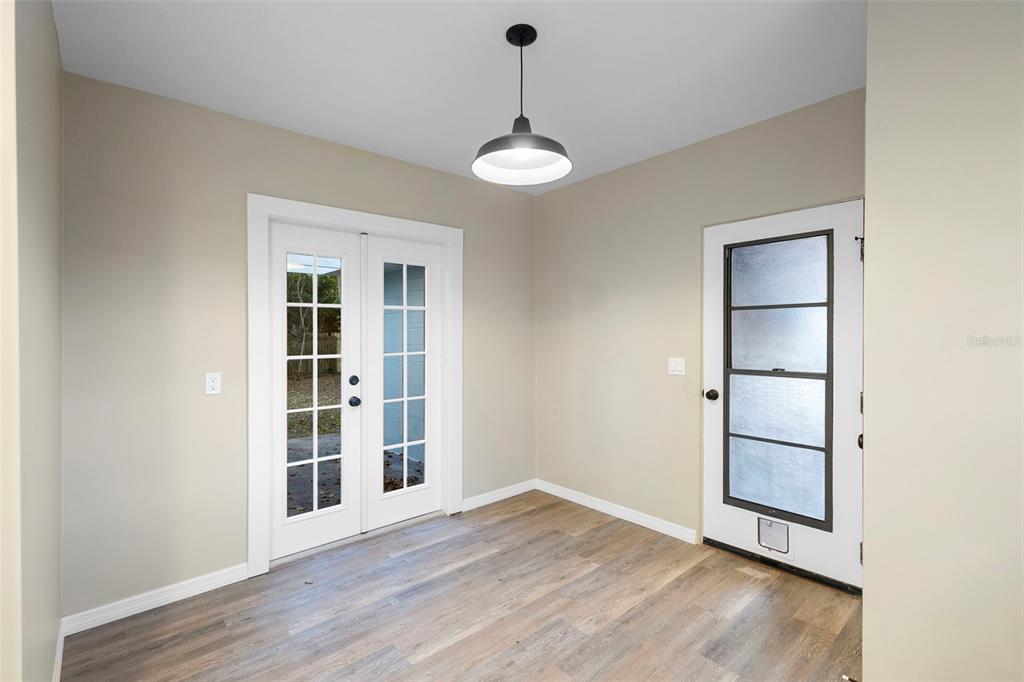 124 Evergreen Avenue Edgewater, FL 32132 - Photo 5 of 36 an empty room with wooden floor cabinet and windows