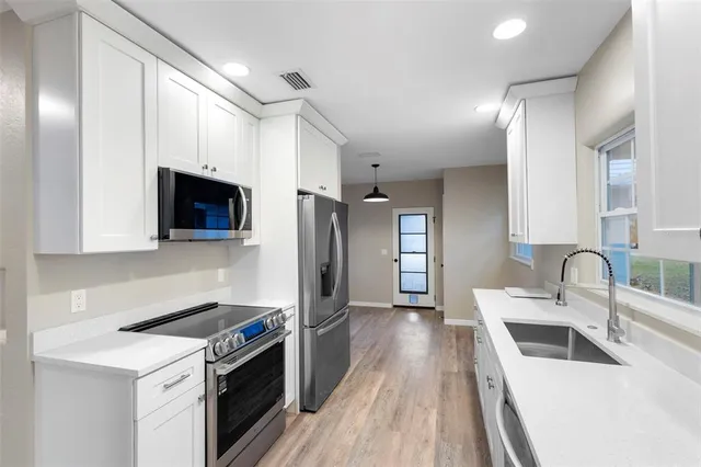 a kitchen with a sink a stove and cabinets