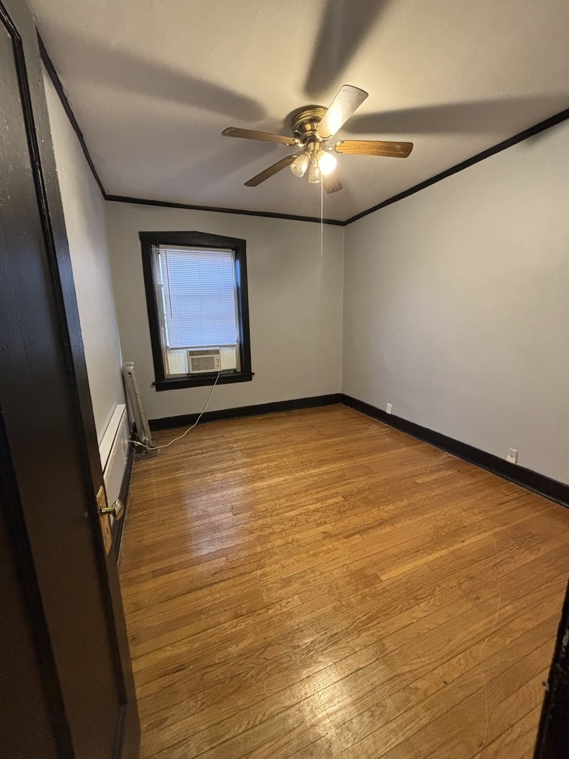 2212 East 70th Street, Unit 2D Chicago, IL 60649 - Photo 4 of 8 en empty room with window and chandelier