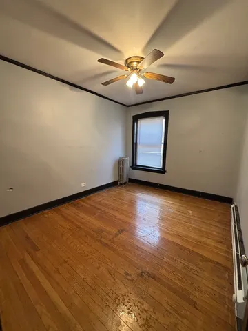 an empty room with a window and wooden floor