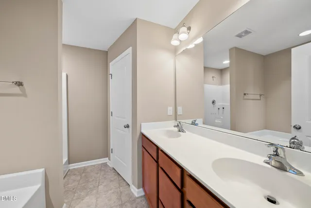 a bathroom with a tub sink double vanity and a mirror