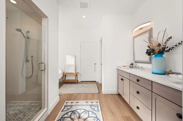 a spacious bathroom with a double vanity sink a mirror and shower