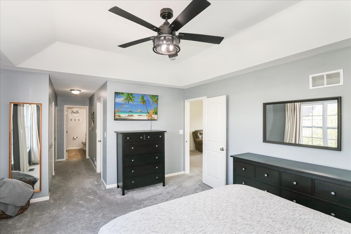 342 Snowdrop Lane Elgin, IL 60124 - Photo 19 of 28 a spacious bedroom with a bed a dresser and a chandelier