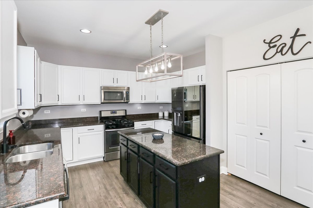 342 Snowdrop Lane Elgin, IL 60124 - Photo 7 of 28 a kitchen with kitchen island granite countertop stainless steel appliances a sink stove and refrigerator